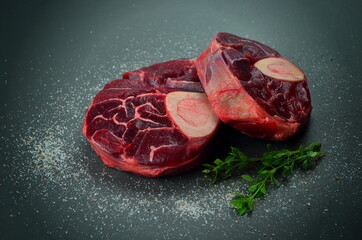 Raw beef shanks with herbs and Himalayan salt on gray background,
fresh cross cut veal shank

