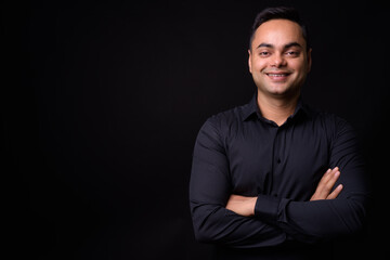 Portrait of happy young handsome Indian businessman