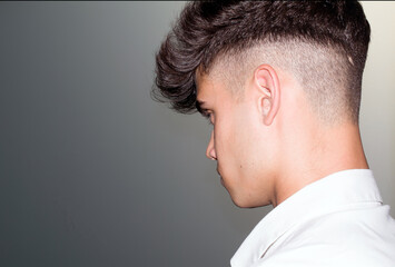 Fototapeta premium Close-up portrait of a modern hairstyle young man, serious, worried, determined. Barber Shop.