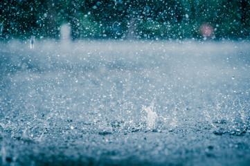 Rain water drop falling to the city street floor in heavy rain day