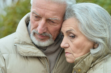 Portrait of sad thoughtful senior couple in park