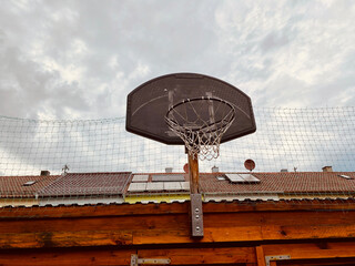 Basketballkorb vor Hausdächer viel Himmel 
