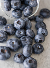 
Blueberries on a white background. And also in a glass with a yellow tube. On a gray background.