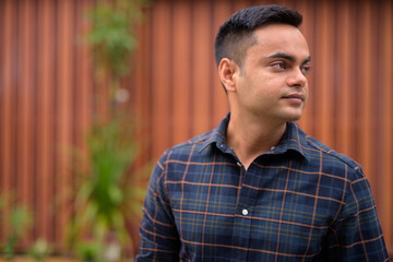 Obraz premium Portrait of young handsome Indian businessman outdoors