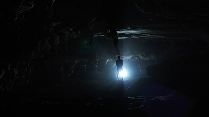 Exploring the dark Pha Thao cave near Pha Tang village in the Vang Vieng area of Laos.