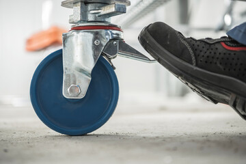 Man Locks Scaffold Wheels For Safety.