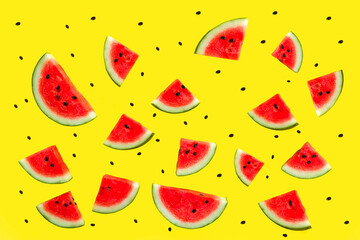 Photo of pieces of fresh ripe red watermelon with seeds pattern on yellow background. Summer concept.