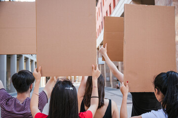 Group of young people during a peaceful demonstration in the city in summer - Millennials holding...