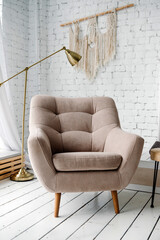 beige armchair in a bright room against a white wall,