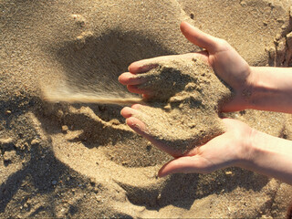 top view of the hands through which the sea sand is pouring. time flies - like sand wakes up through your fingers! sea sand wakes up through the fingers, sandy beach, sea beach