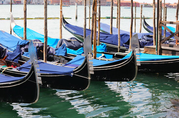 gondolas in the Venice lagoon with the traditional symbol on the