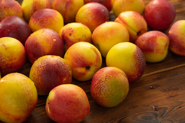 many ripe nectarines on a wooden table. fruit harvest