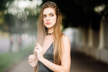 portrait of beautiful young girl in black dress outdoors, attractive woman with long hair