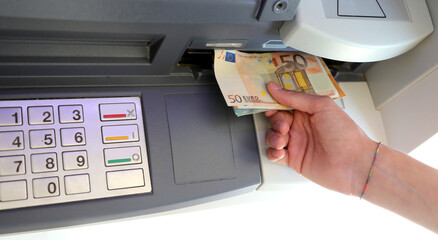 hand of the person withdrawing money in banknotes from an ATM
