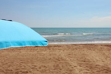 beach umbrella with sand and sea shore in summer