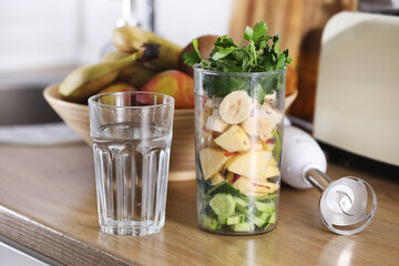 Glass of delicious yogurt with mint and fresh strawberries, banana, lime, nectarine in a wicker basket on a wooden table