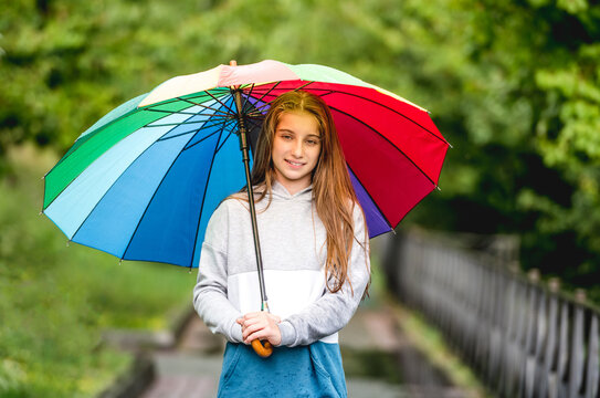Young girl under colorful umbrella
