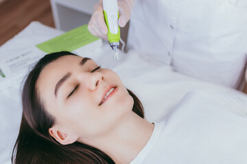 Fractional mesotherapy. A young woman in the cosmetologist’s office receives fractional...
