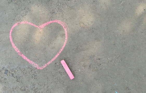 pink heart drawn with chalk on the asphalt. love confession. banner place for text, valentine, children creativity copy space, summer