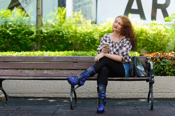 Young woman with curly red hair at the park