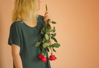 Young lovely girl holding red roses bouquet
