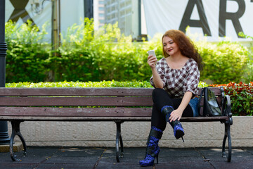 Young woman with curly red hair at the park