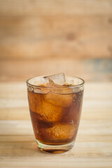 Coca Cola with ice on the wooden floor