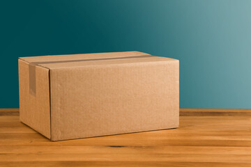 ungeöffnetes Paket auf Holztisch vor blauem Hintergrund