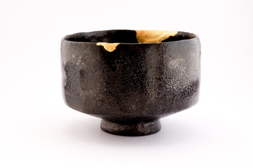 Japanese kintsugi black raku ceramic chawan, restored with real gold. Antique pottery kintsukuroi.