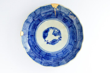 Japanese kintsugi ceramic plate restored with real gold, Antique traditional pottery.
