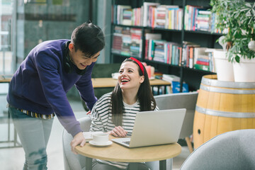 Positive fellow students laughing at the funny joke