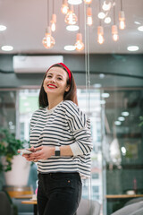 Relaxed young lady with gadget looking away and smiling