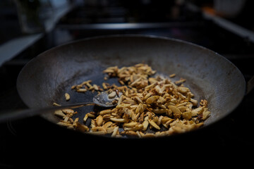 Mandelstifte beim R&ouml;sten in einer schwarzen Gru&szlig;pfanne, Produktbild