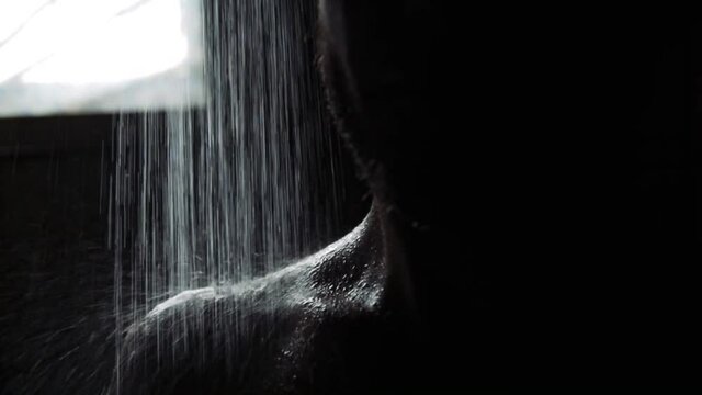 drops fall on the body of men, shoulder and collarbone in the dark, shower.