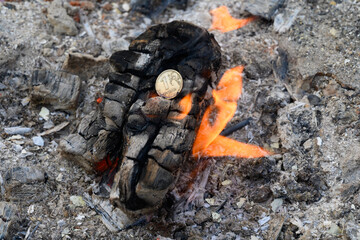 Russian coin in fire on red-hot coal among the ashes. One rubles in fire. Russian currency devaluated, finance and business concept