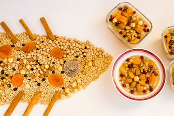 Traditional Turkish Asure Dessert or Noah's Puddings on wwhite with uncooked ingredients in ship shape,top view