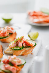 Toasts with fresh cucumber and smoked salmon served with lime shavings