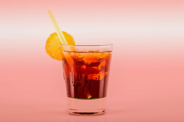 Delicious cocktail in drink glass with lemon and ice cubes, a sweet alcoholic drink based on rum and cola