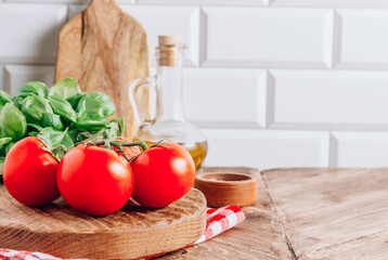 Olive oil, tomato and basil on rustic wooden table. Italian cuisine concept. Ready for cook