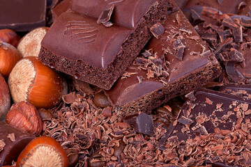 Delicious milk chocolate, nuts and chocolate chips as background