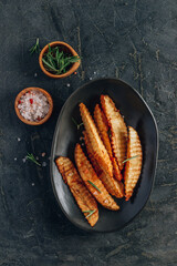 Homemade organic French fries with pink salt and cranberry sauce on black background.