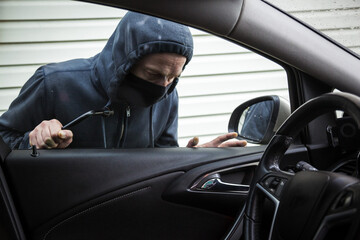 The criminal is trying to hack the car. Car thief.