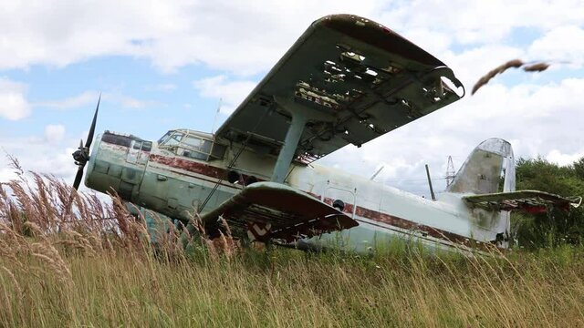 Abandoned Aircraft plane standing in the field against cloudy blue sky. Small propeller plane at the Airplane cemetery
