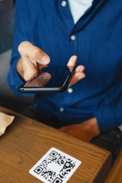 Man Scanning The QR Code With Mobile Phone