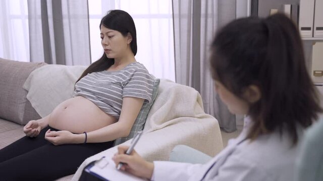 young asian japanese pregnant woman visiting psychologist in clinic. future parenthood lady mental and health care lifestyle concept. depressed motherhood complaining situation of maternity to doctor