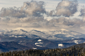 mountains in winter peaks forest-covered clouds in the sky