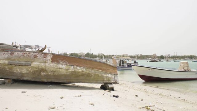 Old damaged boat on beach in Muharraq