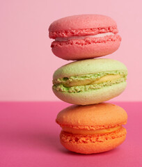 stack of baked macarons on pink background, delicious dessert made from almond flour