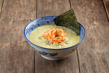 Side view on matcha ramen soup with langoustines