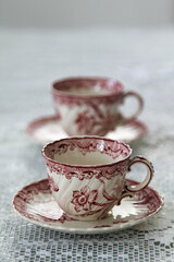 White ceramic coffee cup with pink flower pattern on the table.